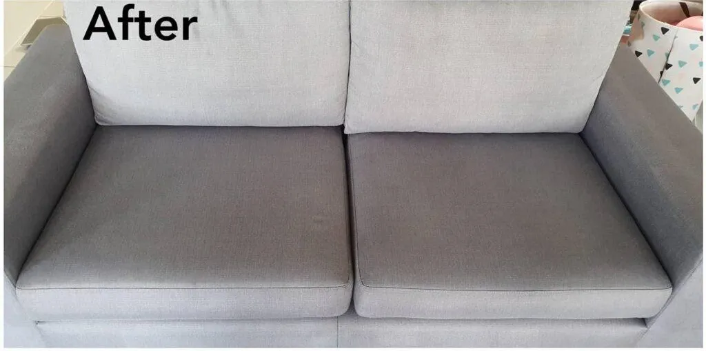 Grey fabric loveseat after cleaning, with the seat cushions looking even